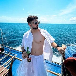 ZAYViK SHARMA standing on a boat by the sea